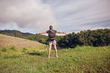 Fototapeta premium guy with a backpack on top of the trail 