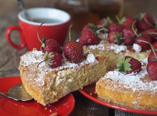 Pastry background. Banana sponge cake with strawberries at the top with a cut piece. Home cooking.