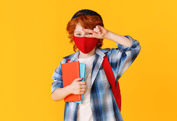 Schoolboy in mask gesturing V sign.