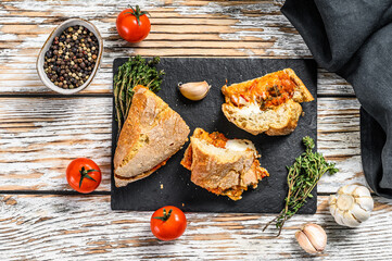 Vegetarian baguette submarine sandwich with grilled eggplant, pepper and feta cheese. White background. Top view