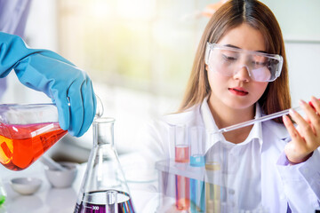 Young Asian scientist woman lab technical service holding flask with lab glassware and test tubes in chemical laboratory background, science laboratory research and development concept