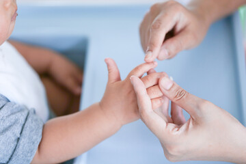 Mother holding baby finger - Bright tone and focus point concept.