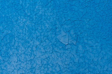 beautifully cracked blue paint on a metal surface. texture of drought and alien surface