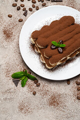 Classic tiramisu dessert on ceramic plate on concrete background