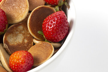 Homemade cereals mini pancake with yogurt, honey and strawberries on colorful background.