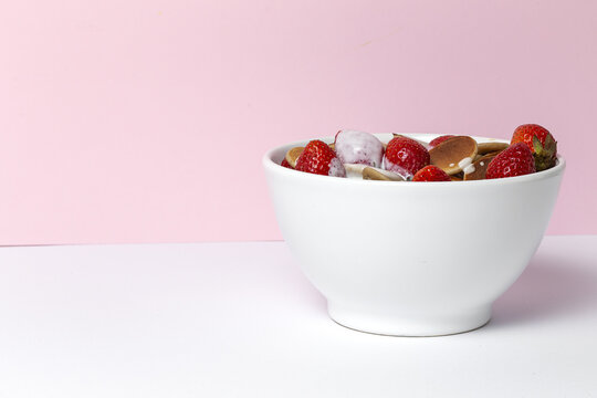 Homemade cereals mini pancake with yogurt, honey and strawberries on colorful background.