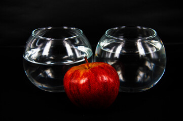 art photo red apple glasses with water on a black background