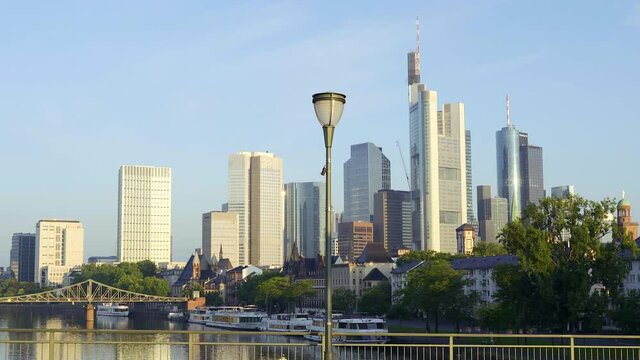 The skyline of Frankfurt in a beautiful gimbal movement shot during sunrise on a local city bridge