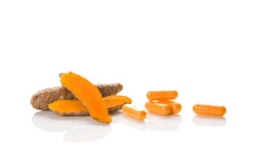 Turmeric capsule with root on white.