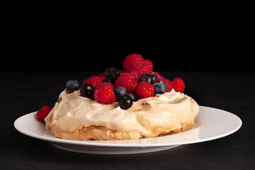 Meringue dessert Pavlova with fresh blackberries and raspberries.