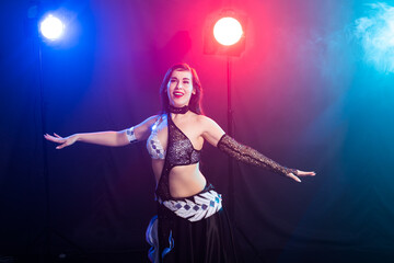 Fototapeta premium Girl dancing belly dance, fusion or tribal. A woman in a beautiful costume demonstrates charming and gentle movements in the dance.