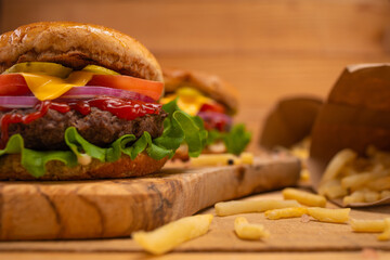 Hamburgers or burgers with french fries on a wooden background, fast food