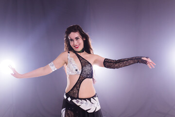 Girl dancing belly dance, fusion or tribal. A woman in a beautiful costume demonstrates charming...