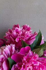 
bouquet of pink peonies in a glass vase on a gray background