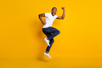 Fototapeta na wymiar Full length body size view of his he nice attractive glad funny childish cheerful cherry guy jumping having fun dancing isolated over bright vivid shine vibrant yellow color background