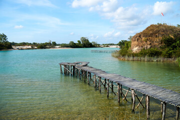 Fototapeta na wymiar Wide angle view of wooden bridge at blue lake