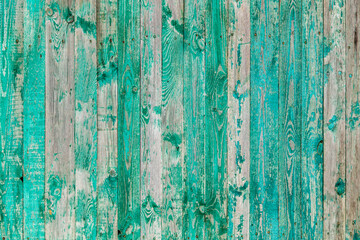 Fototapeta na wymiar Wooden boards on an old green fence as an abstract background.