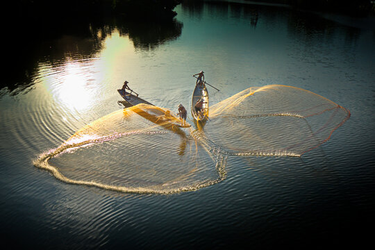 HUE CITY, VIETNAM - JUNE 13, 2020: Unidentified fishermen casting fishing nets on Nhu Y river. Fishing has become their traditional career for hundreds of years and this way still existing.