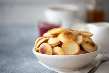 small pancakes with berries, jam and powdered sugar