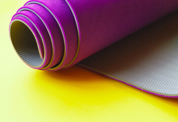 Bright purple yoga mat on a yellow background
