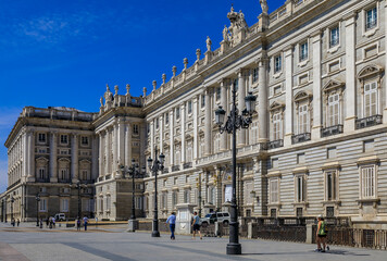 Fototapeta na wymiar Ornate baroque architecture of the Royal Palace viewed from Plaza de Oriente and police car outside in Madrid, Spain