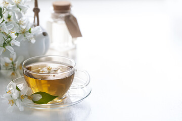 Tea of jasmine flowers on a white background, spa concept. Copy space.