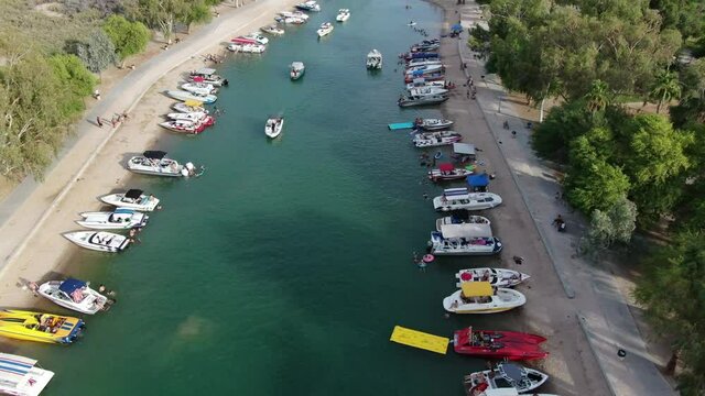 Lake Havasu is a party city with boats on the channel at London Bridge in Arizona and California with parades during sunny summer day with friends and family on vacation captured by 4K drone footage.
