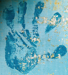 Handprint of blue paint on the wall.