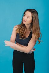 cheerful sports girl smiling and looking into camera on blue background