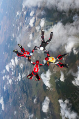 Skydiving photo. Four sports parachutist build a figure in free fall. Extreme sport concept.
