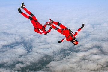 Skydiving photo. Two sports parachutist build a figure in free fall. Extreme sport concept.