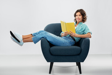 comfort, people and furniture concept - portrait of happy smiling young woman in turquoise shirt...