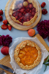 Baked galettes or open strawberry and apricot pies on the table. Homemade pastry