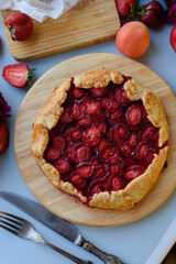 Baked galette or open strawberry pie on the table. Homemade pastry