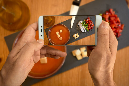 gazpacho scene with person taking pictures with his smart phone selective focus