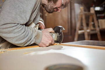 Male carpenter working on old wood in a retro vintage workshop.