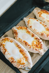 Khachapuri in Adjarian. Open pie with cheese and egg. Georgian cuisine.