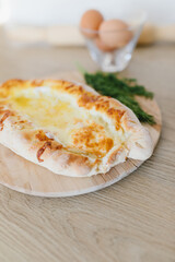 Khachapuri in Adjarian. Open pie with cheese and egg. Georgian cuisine.