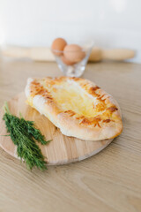 Khachapuri in Adjarian. Open pie with cheese and egg. Georgian cuisine.