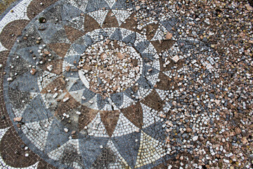 Brown and white ceramic floor mosaic background in flower petal shape with tile pieces ancient history art concept