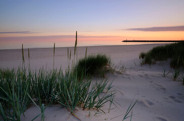 Morze Bałtyckie,wschód słońca na plaży w Kołobrzegu. - obrazy, fototapety, plakaty
