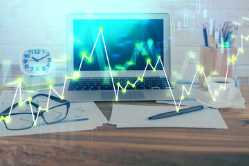 Financial chart drawing and table with computer on background. Multi exposure. Concept of international markets.