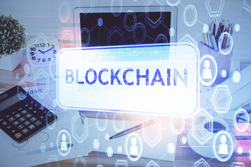 Double exposure of blockchain and crypto economy theme hologram and table with computer background....