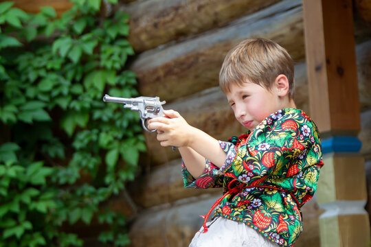 Russian boy in national dress with a gun.