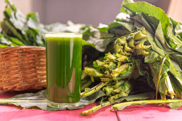 Green detox juice from cabbage leaves on pink background