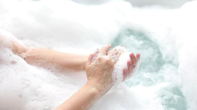 spa hand rub with soap and skincare bubble foam in bathtub