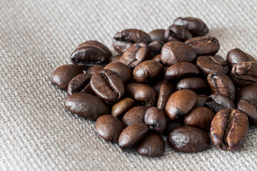 Close-up of coffee beans on linen fabric. Selective focus