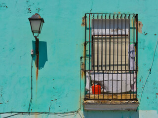 Street views. An orange butane cylinder in contrast to a mint wall. 