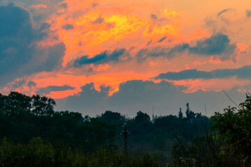 Orange sunset over meadow at spring