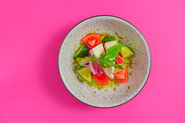 Healthy organic vegan vegetable salad served in a bowl over bright pink background. Spring seasonal concept.